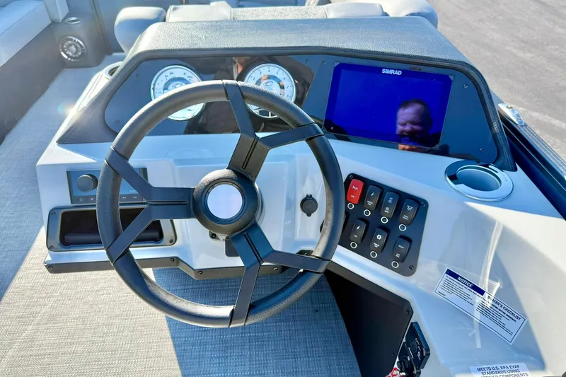 Slide: The Image of 2026 Crest Conquest 210 Fish dashboard with steering wheel, gauges, and Simrad display. - 28
