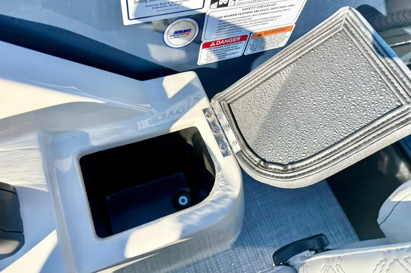 Slide: The Image of Open storage compartment on 2026 Crest Conquest 210 Fish boat with safety labels. - 32