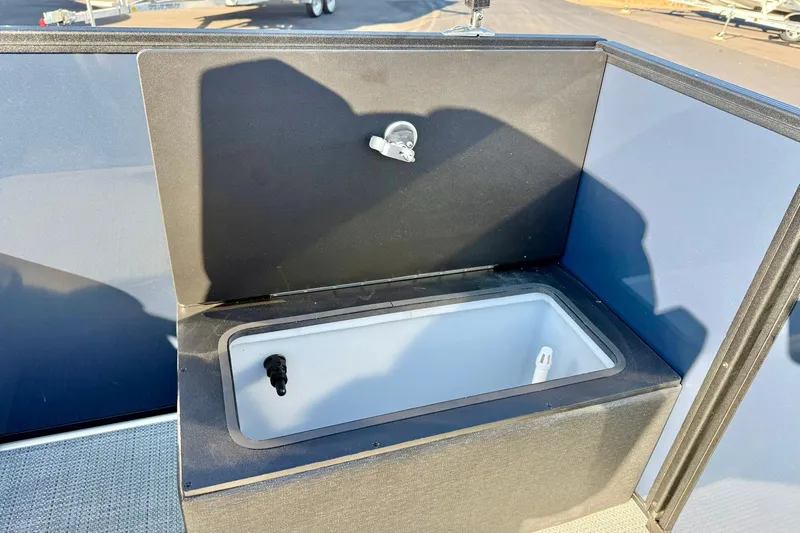 Slide: The Image of 2026 Crest Conquest 210 Fish boat livewell with faucet, open lid, and interior view. - 40