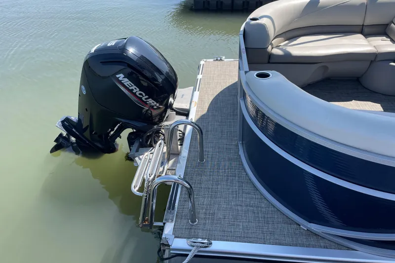 Slide: The Image of 2023 Cypress Cay Seabreeze 232 pontoon boat with Mercury outboard motor, docked on calm water. - 10