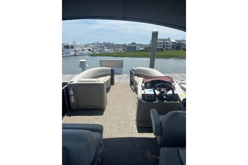 Slide: The Image of 2023 Cypress Cay Seabreeze 232 pontoon boat interior at dock, featuring helm and seating. - 5