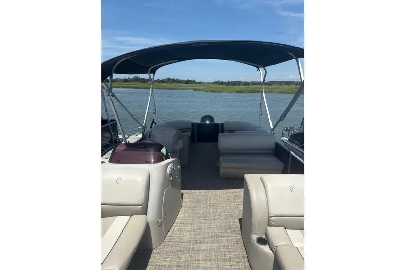 Slide: The Image of 2023 Cypress Cay Seabreeze 232 pontoon boat interior with canopy on a serene lake. - 8