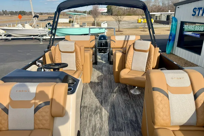 Slide: The Image of 2026 Crest Conquest 230 SLRC boat interior with luxurious tan seating and modern design. - 19