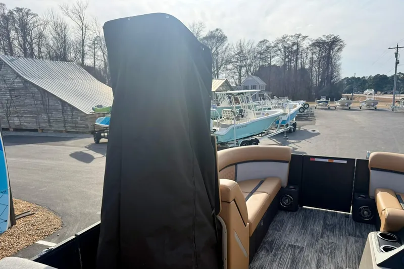 Slide: The Image of 2026 Crest Conquest 230 SLRC pontoon boat with seating, parked in a marina. - 22