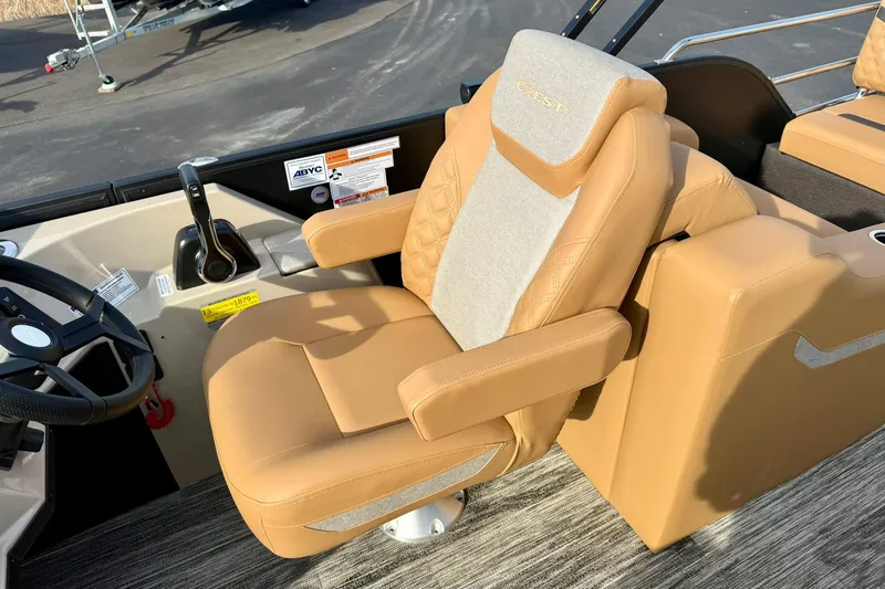 Slide: The Image of Captain's chair in 2026 Crest Conquest 230 SLRC boat, featuring tan upholstery and ergonomic design. - 27