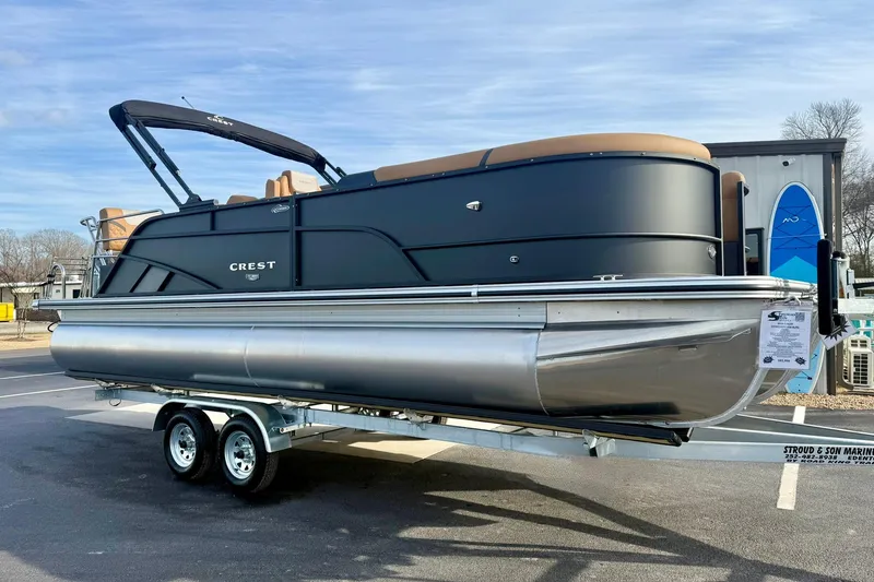 Slide: The Image of 2026 Crest Conquest 230 SLRC pontoon boat on trailer, sleek black design. - 6
