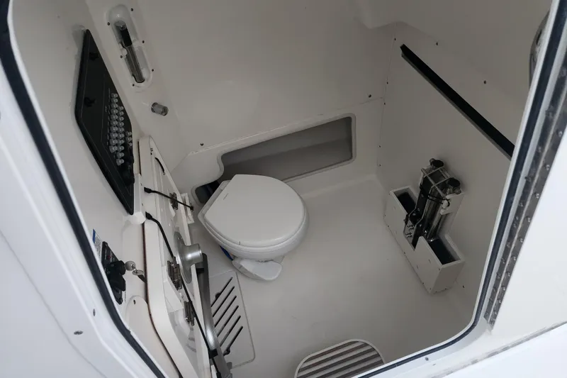 Slide: The Image of 2023 Boston Whaler 280 Outrage cabin interior with toilet and storage compartments. - 11