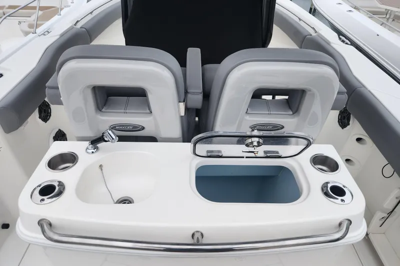 Slide: The Image of 2023 Boston Whaler 280 Outrage boat interior with seating and sink area. - 5