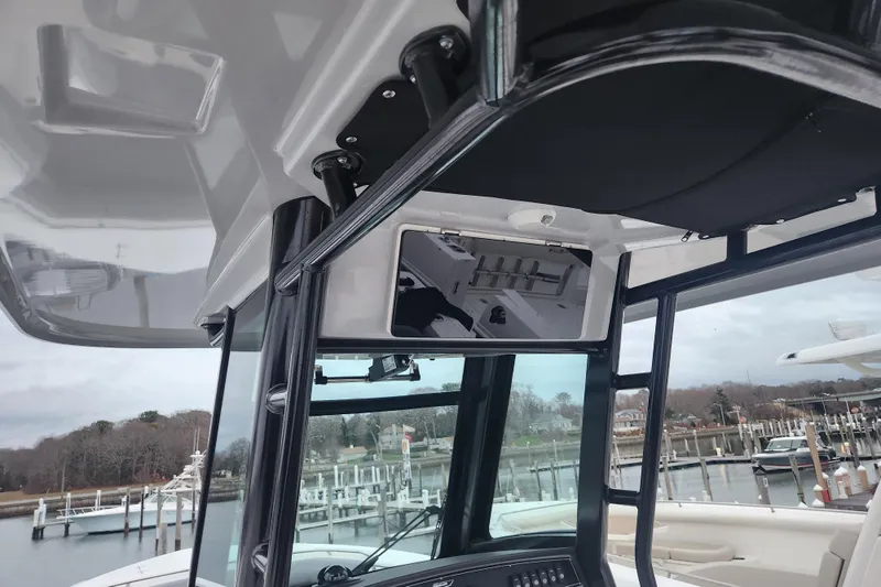 Slide: The Image of 2023 Boston Whaler 280 Outrage boat interior with overhead storage, docked at marina. - 9