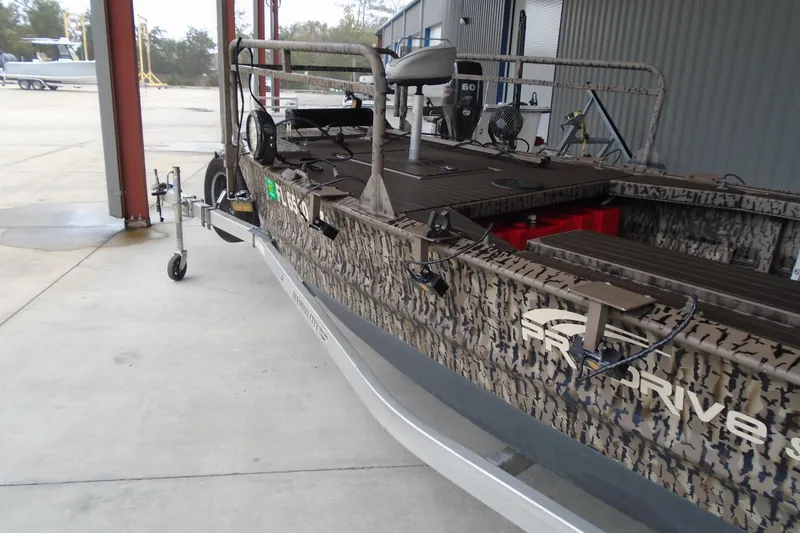 Slide: The Image of 2021 Pro-Drive SBX Series 17' boat with camouflage design, parked on a trailer. - 14