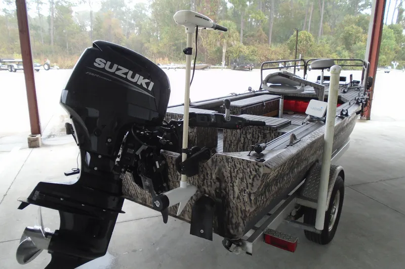 Slide: The Image of 2021 Pro-Drive SBX Series 17' boat with Suzuki motor in a covered area. - 2