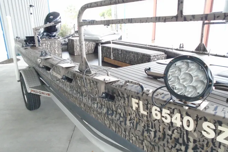 Slide: The Image of 2021 Pro-Drive SBX Series 17' boat with camouflage design and mounted spotlight. - 6