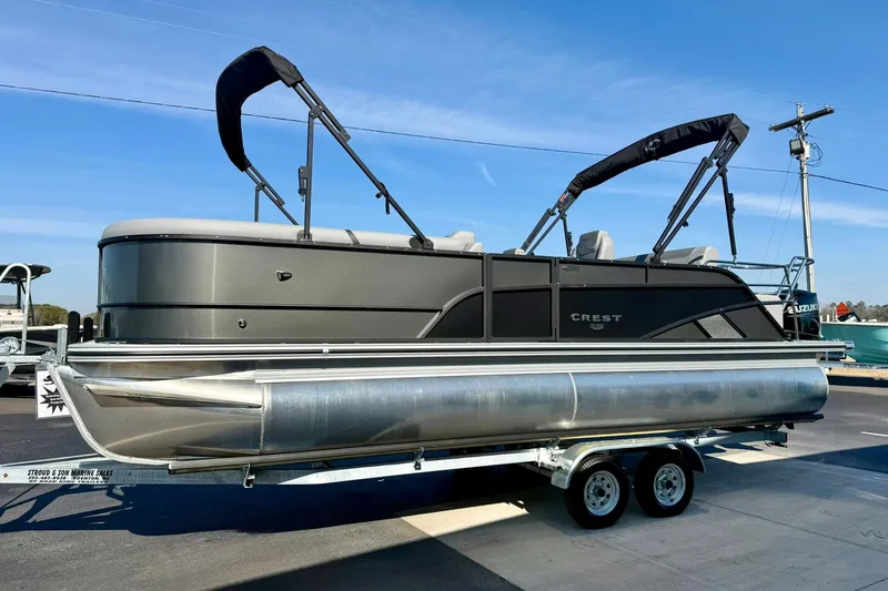 Slide: The Image of 2026 Crest Conquest 235 SLSC pontoon boat on trailer, featuring sleek design and dual bimini tops. - 13