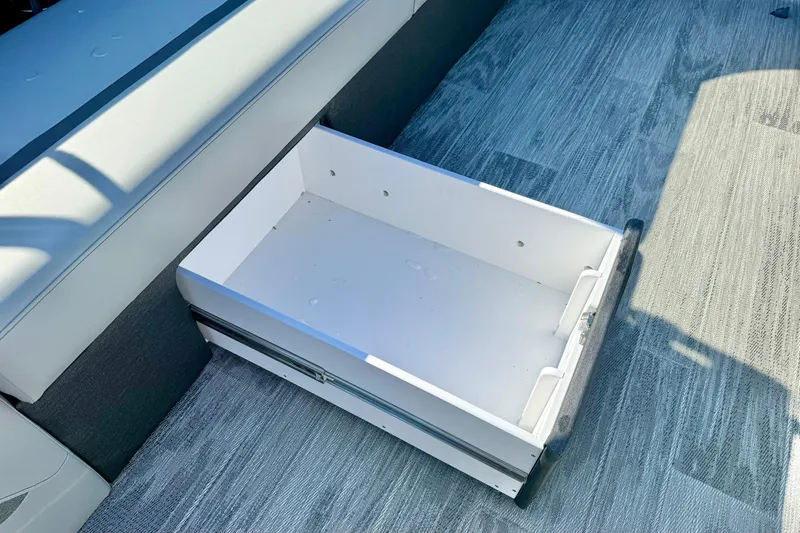 Slide: The Image of Under-seat storage drawer in 2026 Crest Conquest 235 SLSC boat, open and empty. - 21