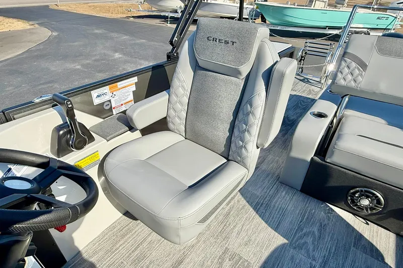 Slide: The Image of Captain's seat in 2026 Crest Conquest 235 SLSC boat, featuring luxurious gray upholstery. - 35
