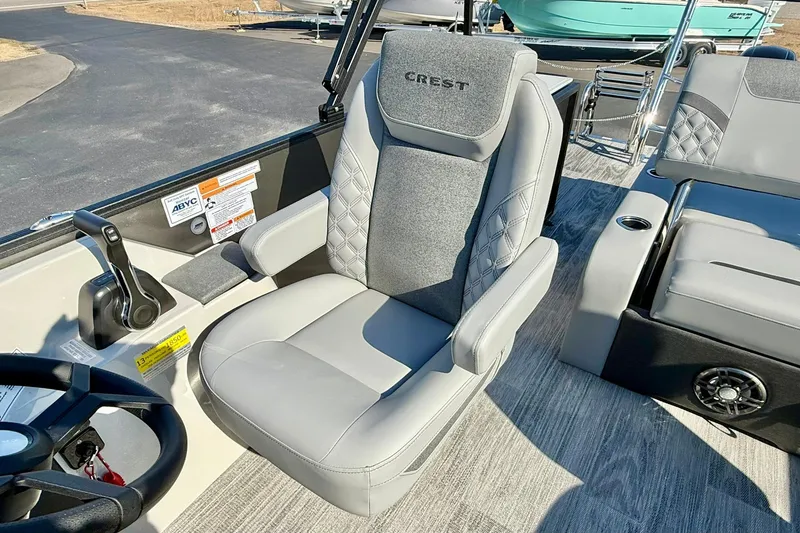 Slide: The Image of Captain's seat of 2026 Crest Conquest 235 SLSC boat, featuring luxurious gray upholstery. - 36