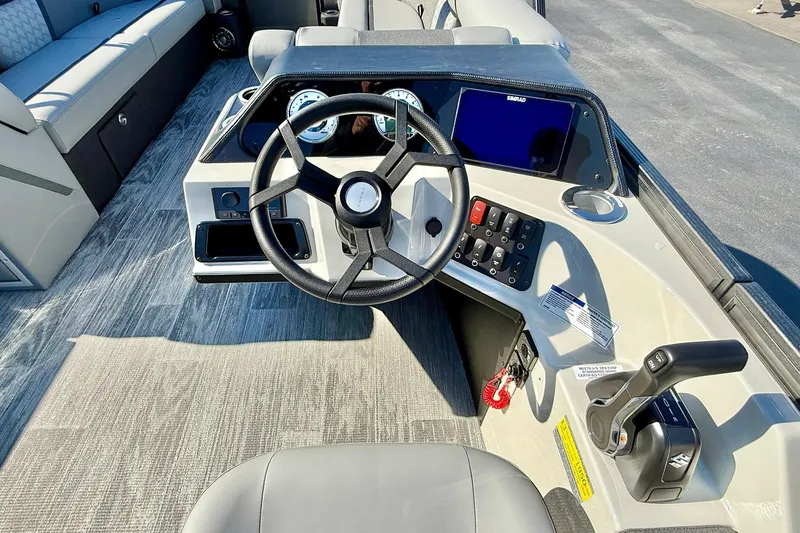 Slide: The Image of 2026 Crest Conquest 235 SLSC boat dashboard with steering wheel and control panel. - 38
