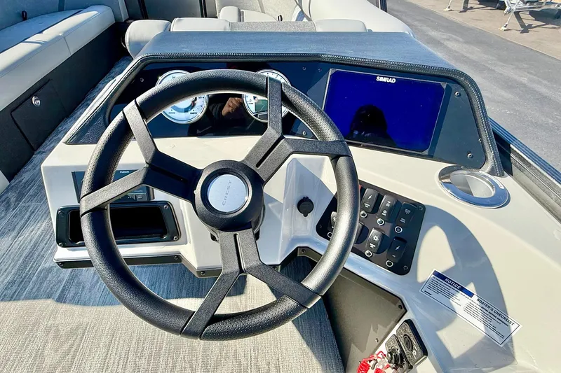 Slide: The Image of Steering console of 2026 Crest Conquest 235 SLSC boat with modern controls and display. - 8