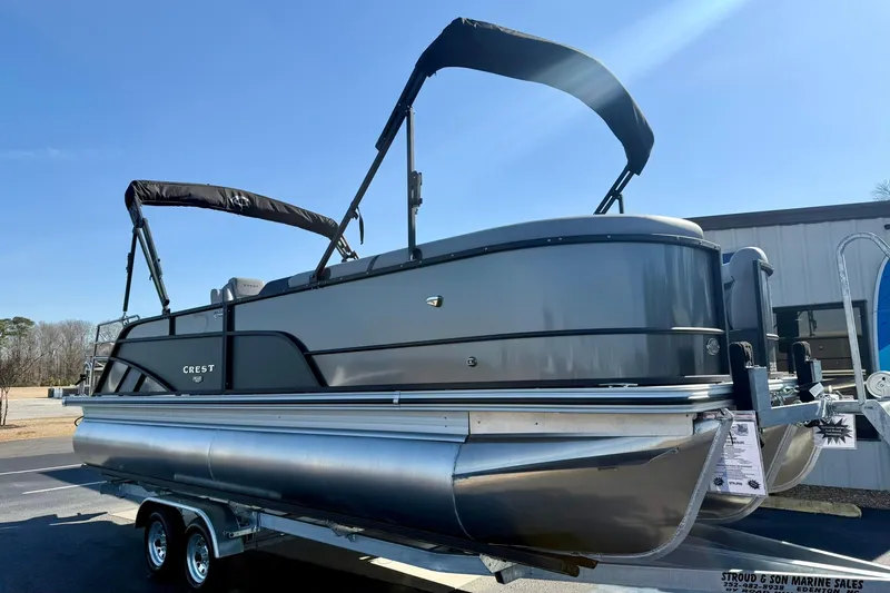 Slide: The Image of 2026 Crest Conquest 235 SLSC pontoon boat on trailer under clear blue sky. - 10