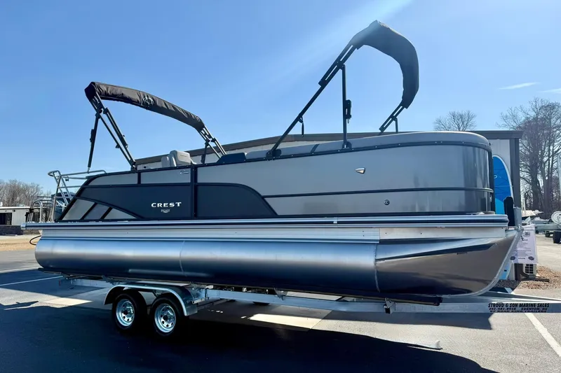 Slide: The Image of 2026 Crest Conquest 235 SLSC pontoon boat on trailer, sunny day. - 12