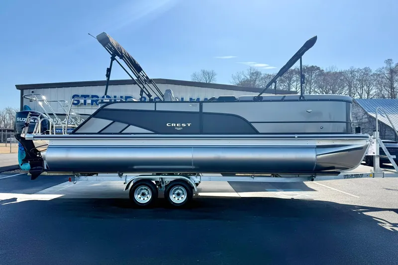 Slide: The Image of 2026 Crest Conquest 235 SLSC pontoon boat on trailer, parked outdoors. - 14