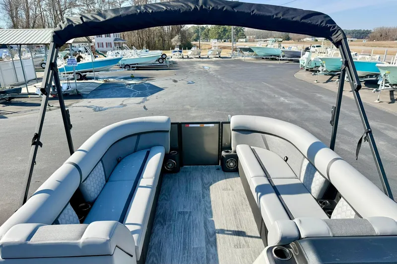 Slide: The Image of 2026 Crest Conquest 235 SLSC pontoon boat with spacious seating and canopy in a marina. - 26