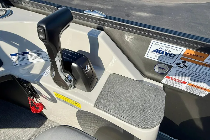 Slide: The Image of Control panel of 2026 Crest Conquest 235 SLSC boat with throttle and safety labels. - 41