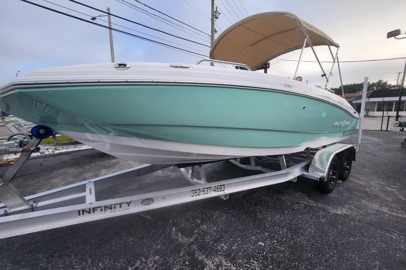 Slide: The Image of 2026 NauticStar 203 SC boat on trailer with canopy, displayed outdoors. - 12