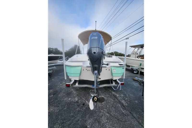 Slide: The Image of 2026 NauticStar 203 SC boat with outboard motor, parked on a trailer. - 3