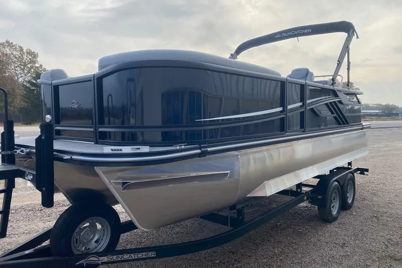 Slide: The Image of 2026 SunCatcher Fusion 322SS pontoon boat on trailer, sleek design, outdoor setting. - 3