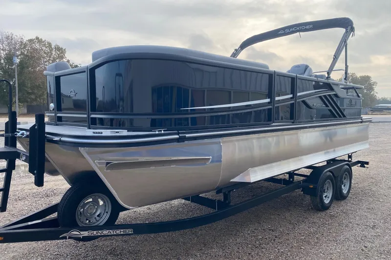 Slide: The Image of 2026 SunCatcher Fusion 322SS pontoon boat on trailer, sleek design, outdoor setting. - 3