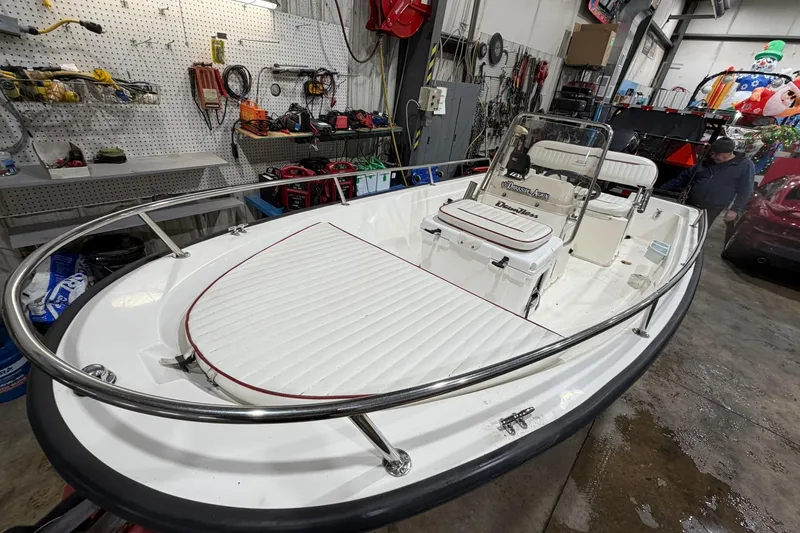 Slide: The Image of 1998 Boston Whaler Dauntless 13 boat in a workshop, surrounded by tools and equipment. - 1
