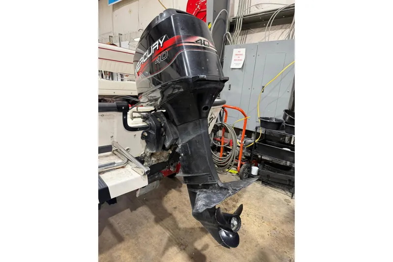 Slide: The Image of 1998 Boston Whaler Dauntless 13 with Mercury 40 outboard motor in a workshop setting. - 10