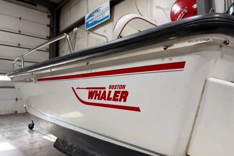 Slide: The Image of 1998 Boston Whaler Dauntless 13 boat in a garage, side view. - 2