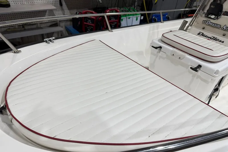 Slide: The Image of 1998 Boston Whaler Dauntless 13 boat interior with white cushioned seating and red trim. - 4