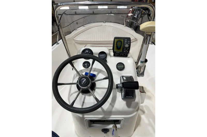 Slide: The Image of 1998 Boston Whaler Dauntless 13 boat dashboard with steering wheel and navigation instruments. - 5