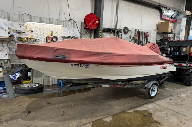 Slide: The Image of 1998 Boston Whaler Dauntless 13 boat with red cover on trailer in garage. - 7