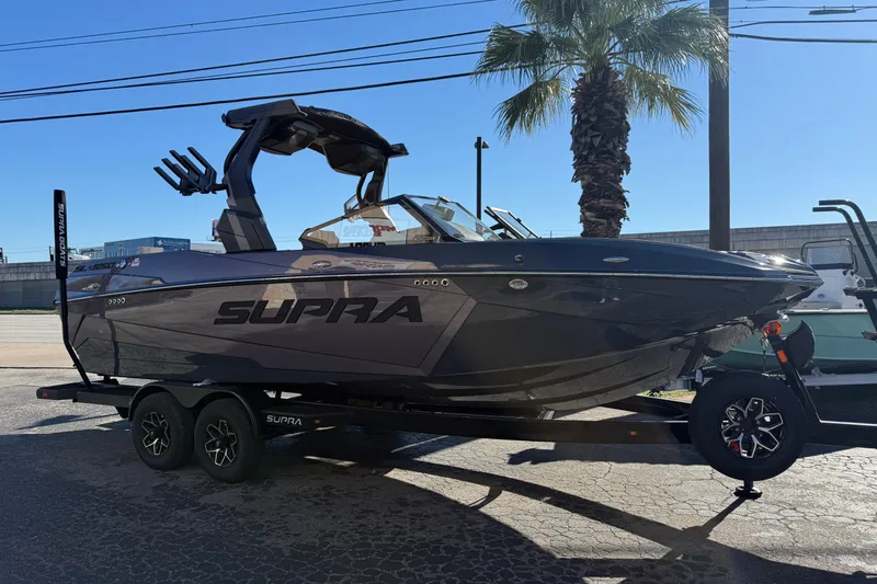 The Image of 2026 Supra SL 550 boat on trailer, parked outdoors under a clear sky. - 1