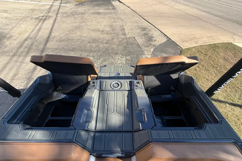 Slide: The Image of 2026 Supra SL 550 boat interior with open storage compartments and brown seating. - 21