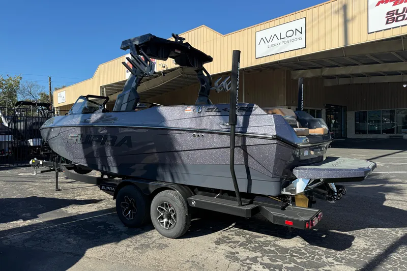 Slide: The Image of 2026 Supra SL 550 boat on trailer outside dealership, showcasing sleek design and modern features. - 5