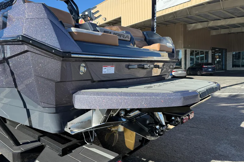 Slide: The Image of 2026 Supra SL 550 boat rear view with swim platform in a dealership setting. - 6