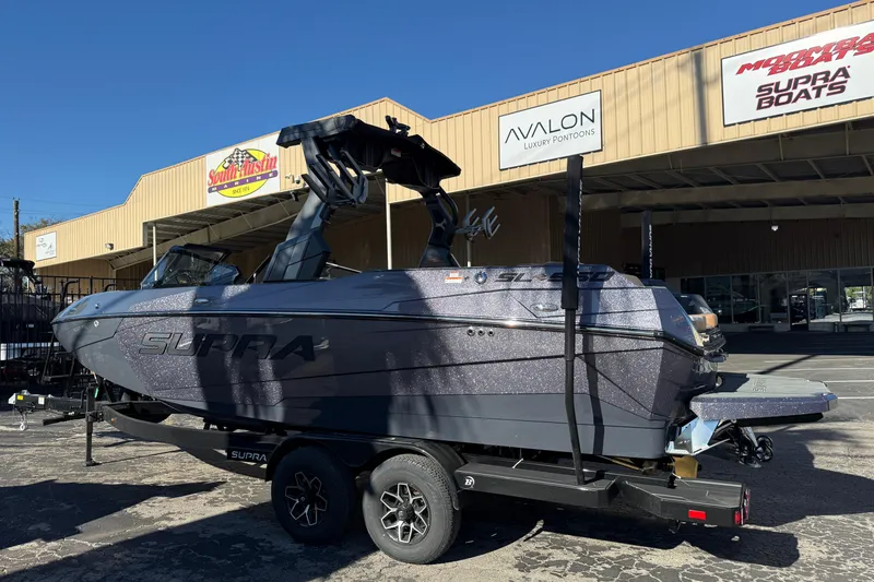 Slide: The Image of 2026 Supra SL 550 boat on trailer outside dealership, showcasing sleek design. - 63