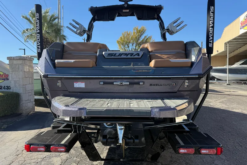 Slide: The Image of 2026 Supra SL 550 boat rear view, featuring Swell Surf system and sleek design. - 7
