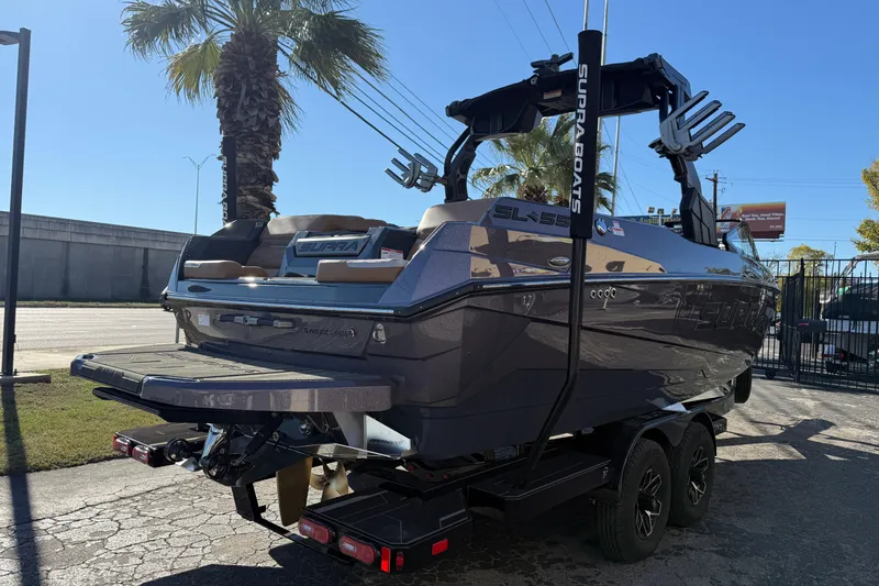 Slide: The Image of 2026 Supra SL 550 boat on trailer, parked outdoors under clear sky. - 8
