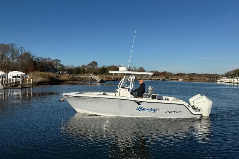 Slide: The Image of 2022 Blackfin 252 CC boat on calm water, clear sky, scenic background. - 2