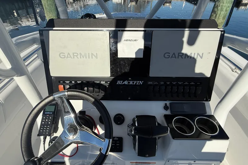 Slide: The Image of 2022 Blackfin 252 CC boat dashboard with Garmin displays and steering wheel. - 25