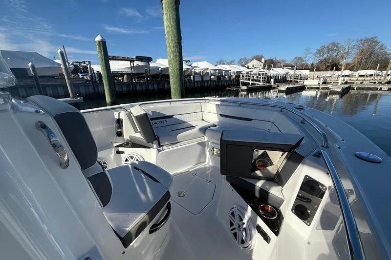 Slide: The Image of 2022 Blackfin 252 CC boat interior with seating and speakers at a marina. - 29