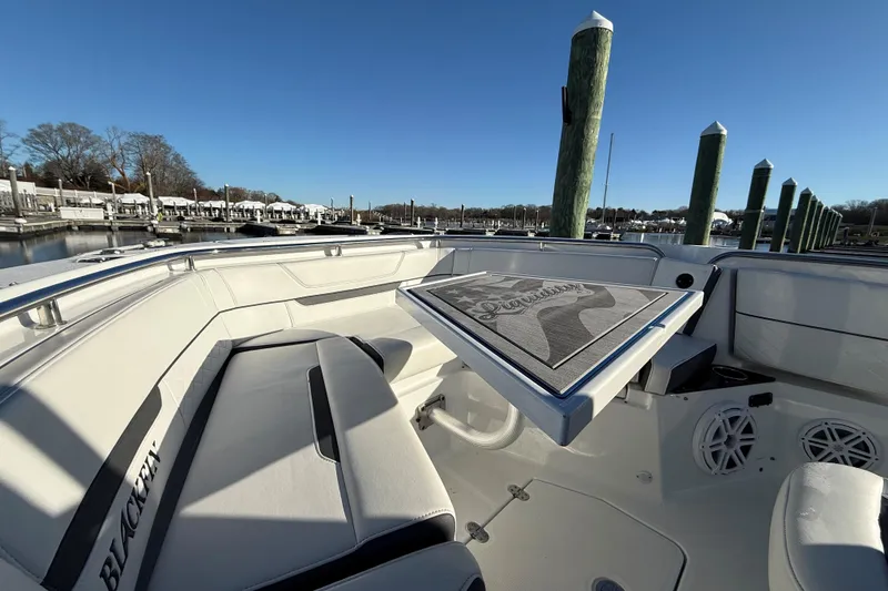 Slide: The Image of 2022 Blackfin 252 CC boat interior with seating and table, docked at marina. - 40