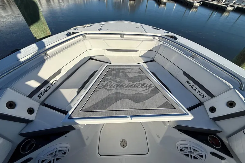 Slide: The Image of 2022 Blackfin 252 CC boat interior with custom "Liquidity" mat, docked by the water. - 41