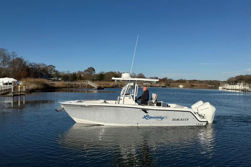 Slide: The Image of 2022 Blackfin 252 CC boat on calm water, clear sky, scenic background. - 49